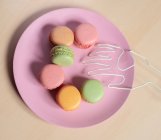 Dall'alto di deliziosi biscotti di macaron colorati disposti a forma di sorriso emoji — Foto stock