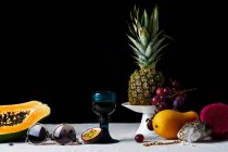 Натюрморт с тропическими фруктами, драгоценными камнями и различными объектами — стоковое фото