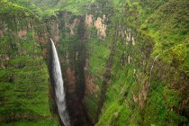 Von oben die atemberaubende Landschaft des großen Jinbar-Wasserfalls mit mächtigem Bach, der die felsige Schlucht hinunterfließt — Stockfoto