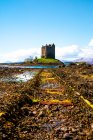 Bright spring landscape with medieval stone castle located on hill near river in green valley in Scottish Highlands in sunny day with cloudy sky — Stock Photo