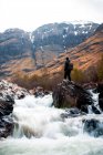 Грубый природный ландшафт с горной рекой, протекающей среди скалистых гор в облачный день в Шотландии — стоковое фото