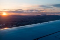 Vista da finestra di ala di aereo moderno che vola sopra nuvole dense durante tempo di tramonto — Foto stock