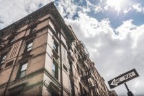 Niedriger Winkel zeitgenössischer Skylines mit Betonfassaden und Verkehrszeichen in eine Richtung auf der Straße von Manhattan — Stockfoto