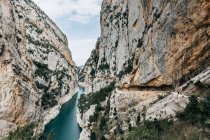 Захватывающий пейзаж спокойной узкой реки с зеленой водой, протекающей среди грубых скалистых скал хребта Монтсек в Испании — стоковое фото