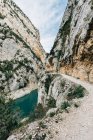 Spettacolare scenario di tranquillo fiume stretto con acqua verde che scorre tra ruvide scogliere rocciose a Montsec Range in Spagna — Foto stock
