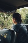 Обратный вид на неузнаваемую путешествующую женщину, сидящую в автомобиле и любующуюся прекрасным видом на парк дикой природы — стоковое фото