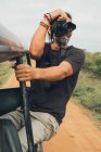 Ethnisch fröhliche männliche Fotograf sitzt im Auto und fotografiert die Natur im Urlaub auf Safari — Stockfoto