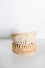 Schnupfen anonymer Zahnarzt in medizinischen Handschuhen hält Zahnersatz in modernen Labor — Stockfoto