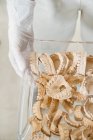 Draufsicht von unkenntlich gemachten Händen, die Tablett mit Stapel verschiedener Zahngips-Modelle von Kiefern im Labor halten — Stockfoto