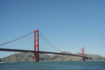 Famosa suspensão Golden Gate Bridge em San Francisco, na Califórnia, com costa montanhosa e céu azul claro no fundo em dia ensolarado — Fotografia de Stock