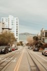 Перспективный вид прямой мощеной дороги с железной дорогой, идущей вниз в районе города Сан-Франциско — стоковое фото