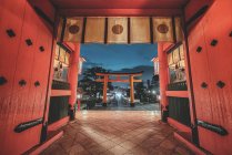 Niedriger Winkel des religiösen Schreins mit Torii-Toren und roten Holzwänden in Kyoto am Abend — Stockfoto
