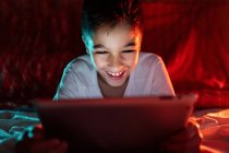 Восхитительный мальчик смотрит мультфильм на планшете — стоковое фото
