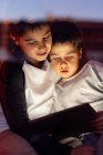 Carino fratelli guardando cartone animato su tablet insieme — Foto stock