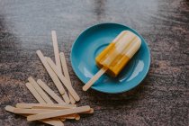 Vue de dessus de délicieux fruits popsicle placé sur la table avec des bâtons en bois — Photo de stock