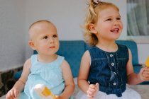 Carino bambine mangiare ghiaccioli gustosi mentre godendo l'estate e seduti insieme in cortile — Foto stock