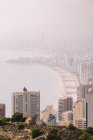 Городской пейзаж плотно построенного района города Бенидорм с современными небоскребами, покрытыми дымкой в Испании — стоковое фото