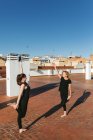 Женщины практикуют йогу вместе на крыше — стоковое фото