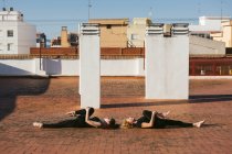Mujeres practicando yoga supino posan juntas - foto de stock