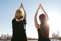 Mulheres realizando saudação solar durante a prática de ioga — Fotografia de Stock