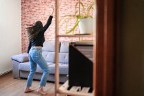 Anonyme Frau tanzt zu Hause. Sie hat den Rücken gekehrt. Dahinter steht eine Mauer — Stockfoto