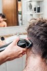 Maschio con tagliacapelli taglio capelli di ragazzo in bagno contemporaneo a casa — Foto stock