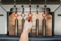 Crop man touching metal springs on hooks of modern pilates reformer placed in gym — Stock Photo
