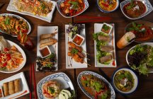 Top view of spicy Thai food served on wooden table with chopsticks — Stock Photo