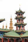 Vista ad angolo basso di pagoda e tempio musulmano con cielo coperto — Foto stock