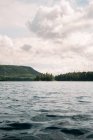 Озеро тихе посеред лісу з зеленими деревами проти хмарного неба в Національному парку Маурічі в Квебеку (Канада). — стокове фото