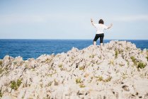 Неузнаваемая женщина стоит на холме на природе — стоковое фото