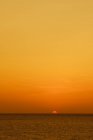 Удивительный золотой закат над тёмным океаном — стоковое фото
