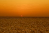 Дивовижний золотий захід сонця над темним океаном — стокове фото