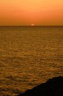 Increíble puesta de sol dorada sobre el océano oscuro - foto de stock