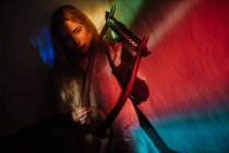 Woman playing lyre under colorful light — Stock Photo