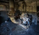 Construction métallique avec tuyau installé à l'intérieur bâtiment industriel abandonné grungy avec des murs minables — Photo de stock