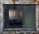 Frammento di muro di pietra intemperie con piccola finestra sporca di edificio industriale abbandonato — Foto stock