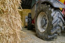 Dirty tractor wheel in garage on farm — Foto stock