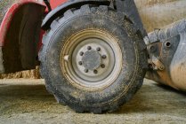 Dirty tractor wheel in garage on farm — Stock Photo