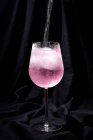 Gim coquetel tônico com água tônica rosa, pimenta rosa, alecrim, hortelã, canela, limão e laranja no fundo escuro — Fotografia de Stock