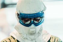 Serious professional doctor in protective uniform and mask standing in modern operating room — Stock Photo