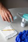 From above male therapist in medical gown sitting at table in hospital and sanitizing hands with antiseptic while preparing for treatment of patients during coronavirus outbreak — Fotografia de Stock