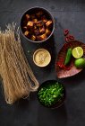 Ingredientes para cocinar ramen vegetariano con tofu colocado en el fondo oscuro - foto de stock