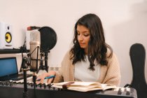 Талантливая женщина-музыкант играет на электропианино и сочиняет музыку в творческой домашней студии — стоковое фото