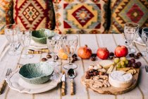 Mesa servida com utensílios de mesa e frutas maduras variadas e deliciosos aperitivos no terraço — Fotografia de Stock