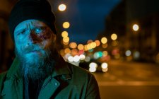 Hipster homme avec barbe et maquillage de cinéma posant dans la rue — Photo de stock