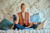 Homem loiro praticando meditação com os olhos fechados em casa — Fotografia de Stock