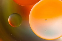 Крупним планом абстрактний фон з круглими клітинами вакцини різного розміру, освітленими барвистим світлом — стокове фото
