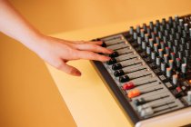 Crop hand of woman using equalizer in music studio on blurred background — Stock Photo