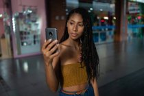 Portrait of attractive young afro latin woman using a smartphone in a commercial mall, Colombia — Stock Photo